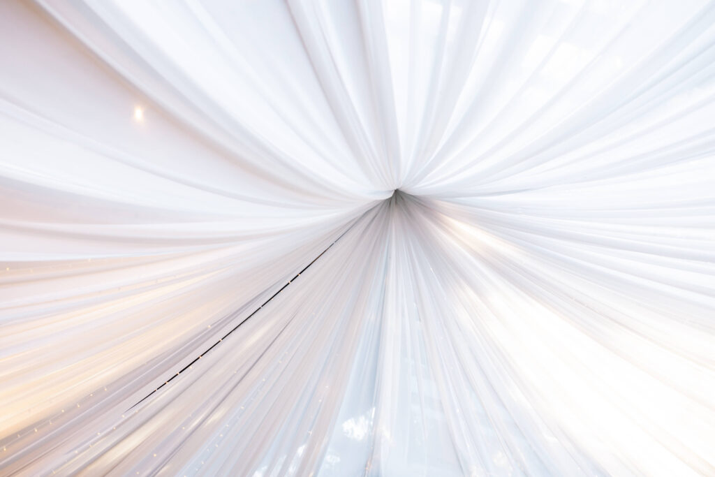 Calamigos Ranch Oak Room Wedding Reception - White draped fabric ceiling gathered at a central point, creating a soft and elegant tent-like effect with gentle lighting. Copyright - Lisa Leanne Photography, California